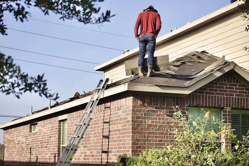 Professional roofer working on a residential roof in Laurel Lake